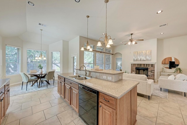 kitchen featuring a fireplace, a kitchen island with sink, ceiling fan with notable chandelier, sink, and black dishwasher