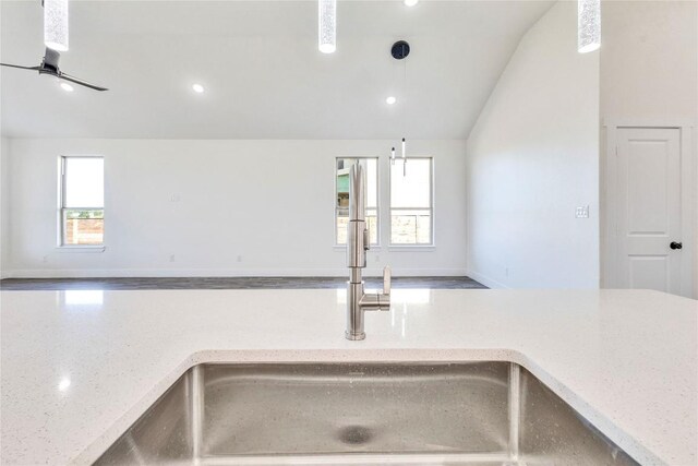 kitchen with lofted ceiling, a wealth of natural light, and sink