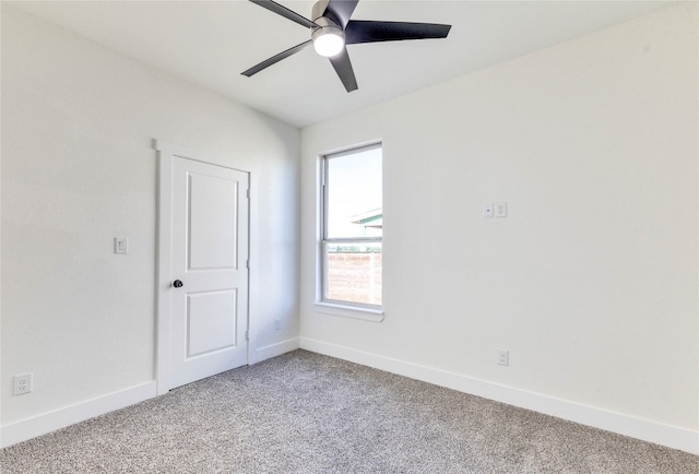 carpeted spare room with ceiling fan