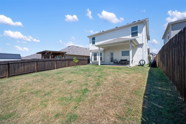 rear view of property featuring a lawn and a patio