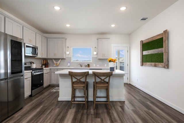 kitchen featuring a center island, stainless steel appliances, and dark wood-type flooring