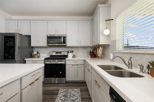 kitchen with pendant lighting, sink, dark hardwood / wood-style floors, tasteful backsplash, and stainless steel appliances