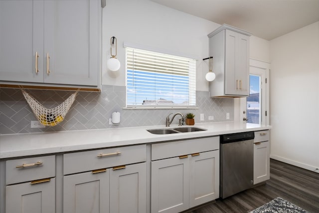 kitchen with dark hardwood / wood-style flooring, backsplash, sink, dishwasher, and gray cabinets