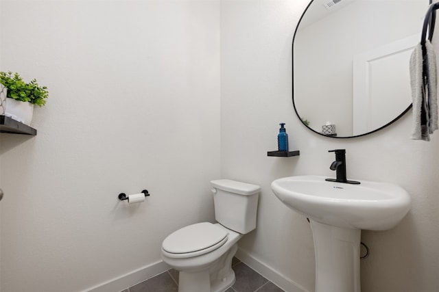 bathroom with toilet and tile patterned floors