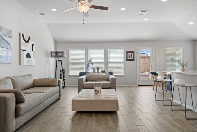 living room with light hardwood / wood-style flooring, ceiling fan, and vaulted ceiling