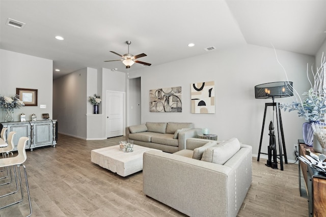 living room with light hardwood / wood-style flooring, ceiling fan, and vaulted ceiling