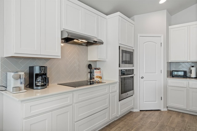 kitchen featuring backsplash, appliances with stainless steel finishes, ventilation hood, white cabinetry, and light wood-type flooring