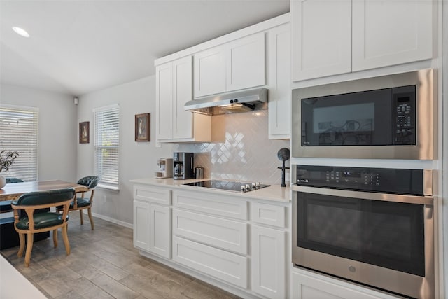 kitchen featuring white cabinets, light hardwood / wood-style flooring, black appliances, extractor fan, and decorative backsplash