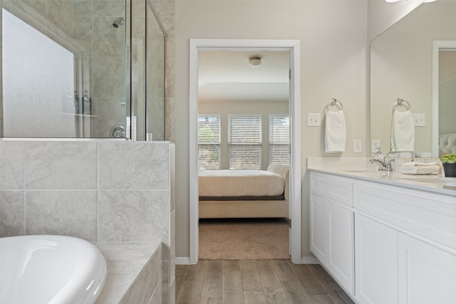 bathroom featuring hardwood / wood-style floors, independent shower and bath, and vanity