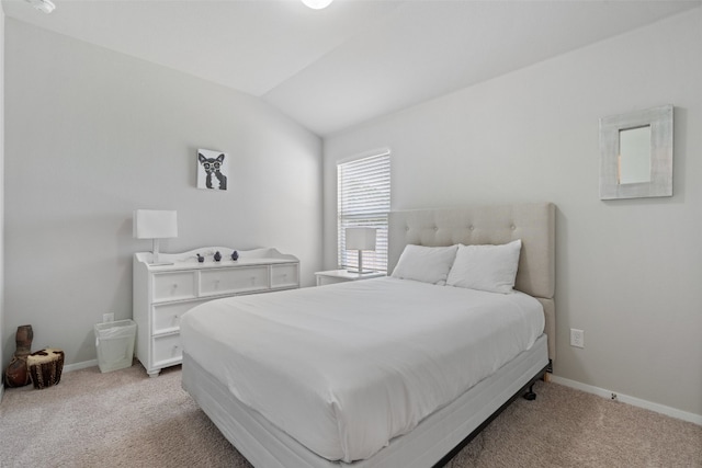 bedroom with vaulted ceiling and light colored carpet