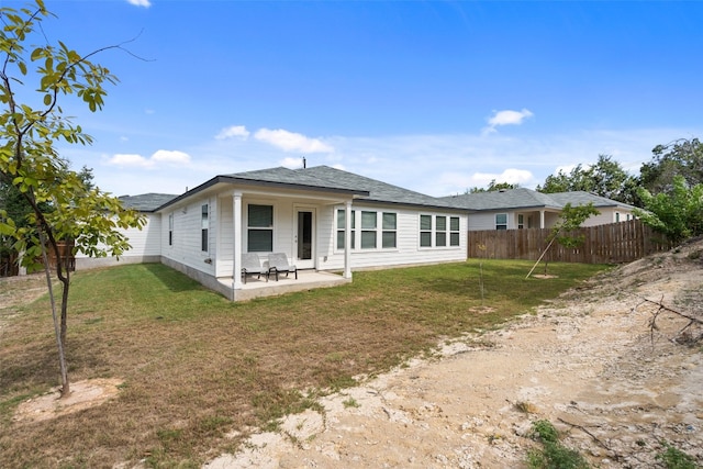 back of house with a yard and a patio