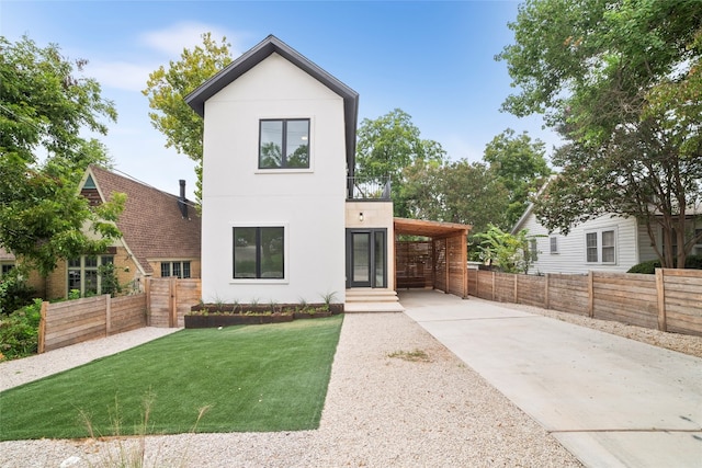 contemporary home featuring a front lawn and a carport