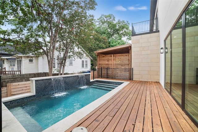 view of pool with a wooden deck and pool water feature