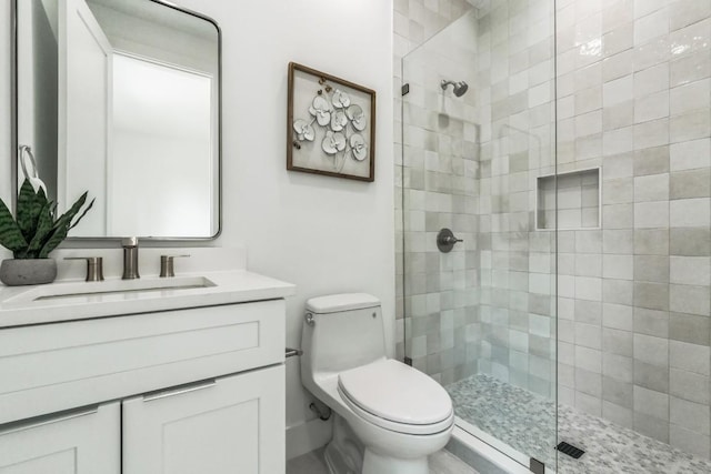 bathroom featuring vanity, toilet, and tiled shower