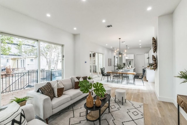 living room featuring light hardwood / wood-style flooring and an inviting chandelier