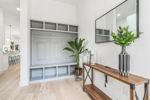 mudroom featuring a notable chandelier and light hardwood / wood-style floors