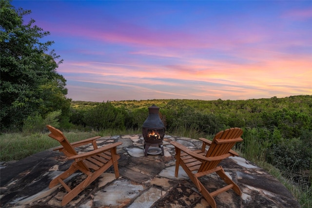 patio terrace at dusk featuring an outdoor fire pit