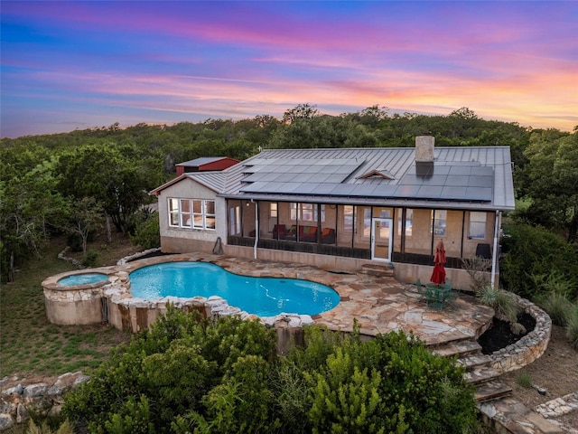 pool at dusk featuring a patio