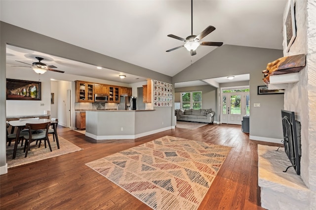 living room with high vaulted ceiling, hardwood / wood-style floors, and ceiling fan