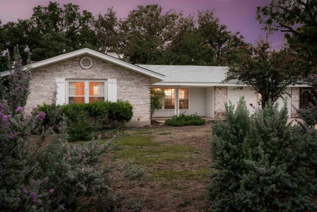 ranch-style house featuring brick siding and a front yard