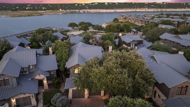 aerial view at dusk featuring a water view