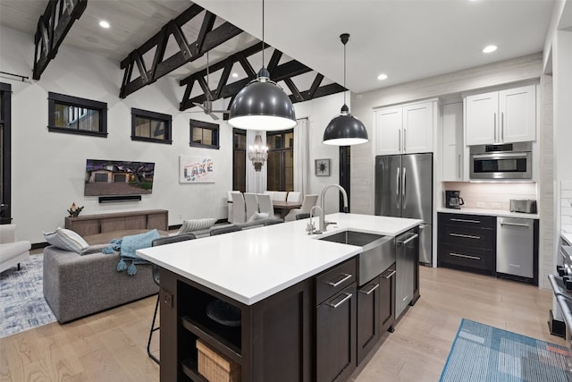 kitchen featuring appliances with stainless steel finishes, white cabinetry, sink, and light hardwood / wood-style floors