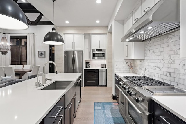 2105 Keeneland Cv Unit 6, Spicewood, TX 78669 - kitchen with under cabinet range hood, appliances with stainless steel finishes, light countertops, white cabinetry, and pendant lighting