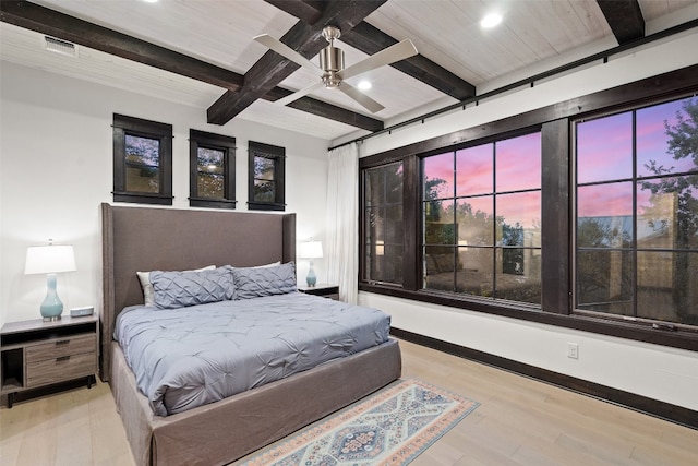 bedroom featuring light wood-type flooring, ceiling fan, and beam ceiling