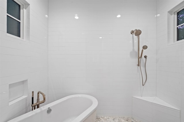 bathroom featuring tile walls and separate shower and tub