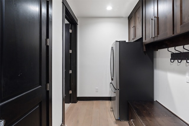 kitchen with light hardwood / wood-style flooring, stainless steel refrigerator, and dark brown cabinetry