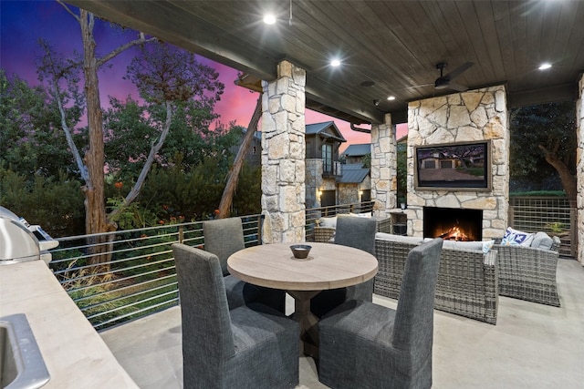 patio terrace at dusk featuring an outdoor living space with a fireplace