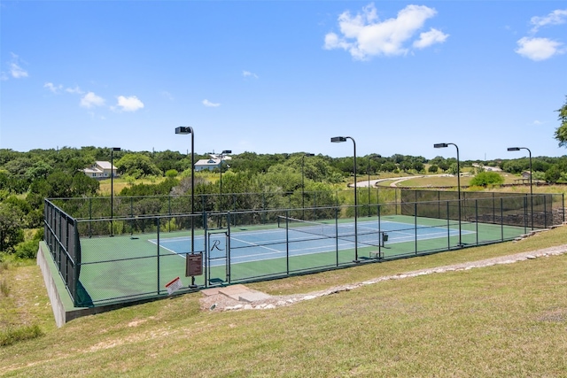 view of tennis court featuring a yard