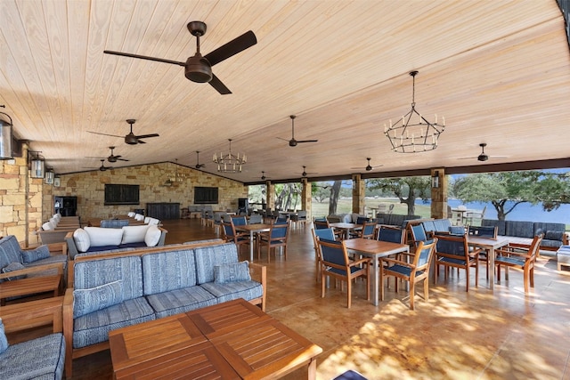 dining room with ceiling fan with notable chandelier, wooden ceiling, a fireplace, concrete flooring, and lofted ceiling