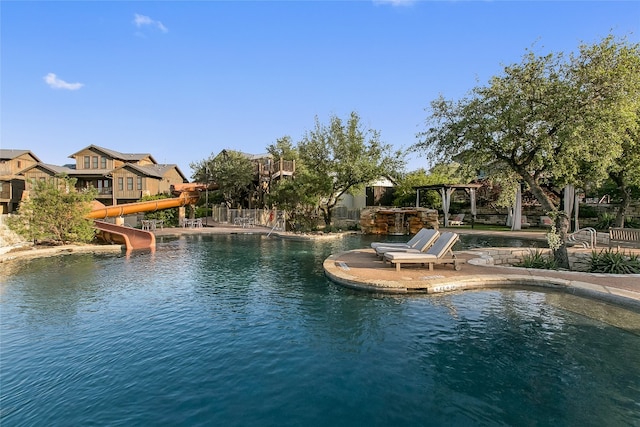 view of pool with a water slide and a patio area