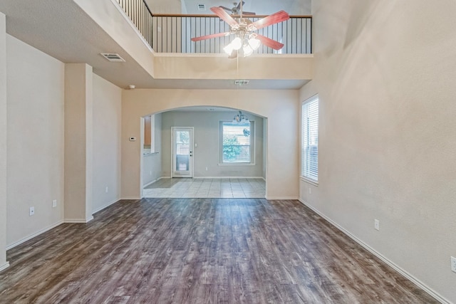 interior space with hardwood / wood-style flooring, a high ceiling, and ceiling fan