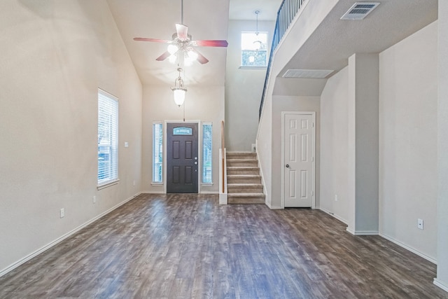 foyer entrance with plenty of natural light, dark hardwood / wood-style flooring, and high vaulted ceiling