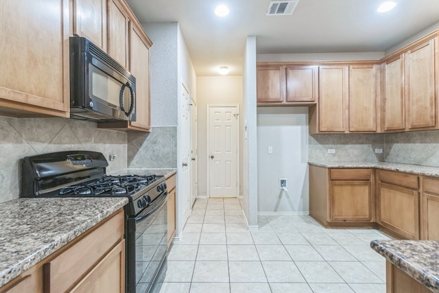 kitchen featuring black appliances, tasteful backsplash, light tile patterned floors, and light stone countertops