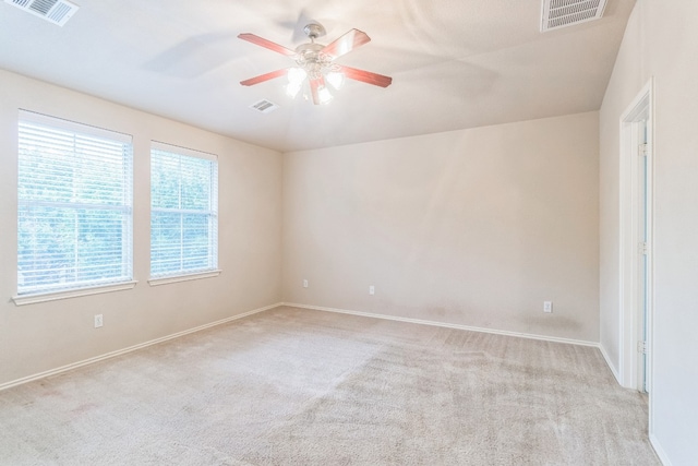 unfurnished room with light colored carpet, a wealth of natural light, and ceiling fan