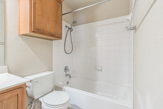 full bathroom featuring tiled shower / bath, vanity, and toilet