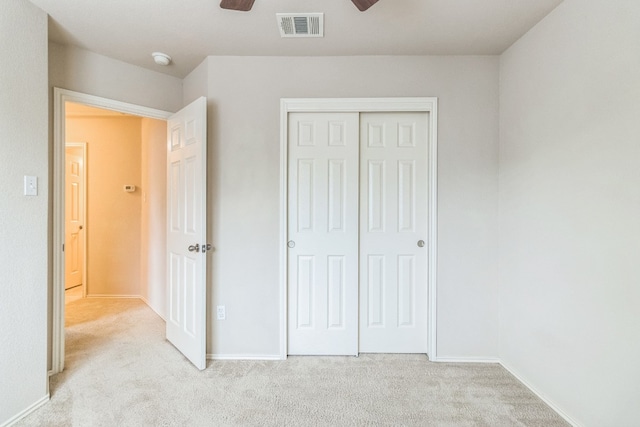 unfurnished bedroom featuring a closet, ceiling fan, and light carpet