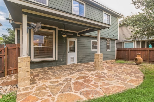 rear view of property featuring ceiling fan and a patio