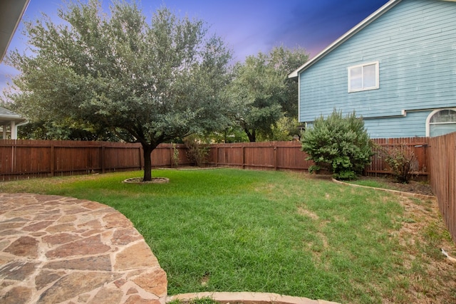 yard at dusk featuring a patio