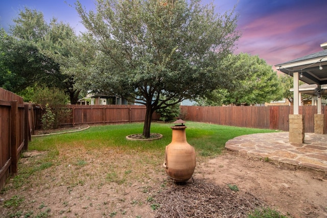 yard at dusk featuring a patio area