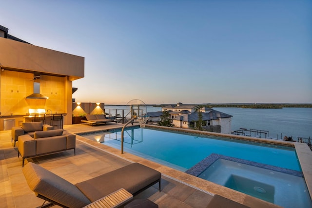 pool at dusk featuring a water view, a patio, an in ground hot tub, and outdoor lounge area