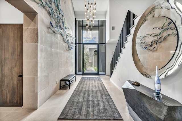 entryway featuring tile walls, light tile patterned floors, and a chandelier