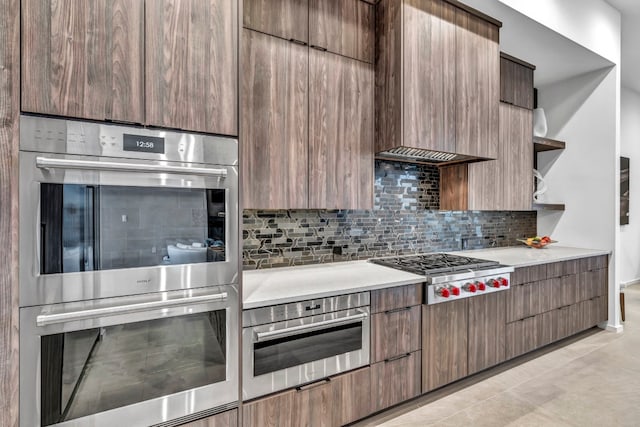 kitchen with appliances with stainless steel finishes, tasteful backsplash, and light tile patterned flooring