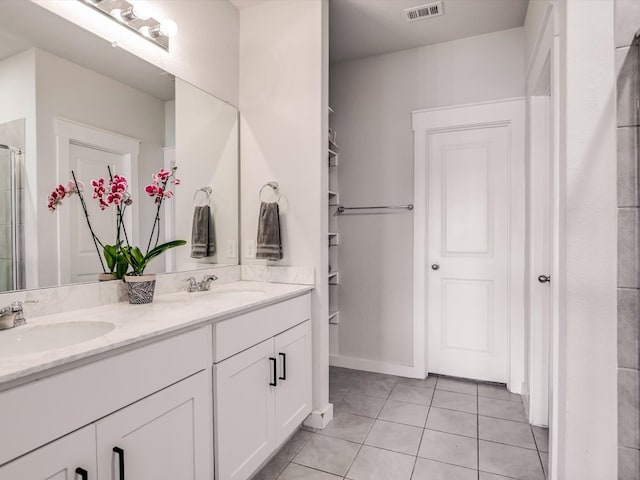 bathroom featuring tile patterned floors, a shower with door, and vanity