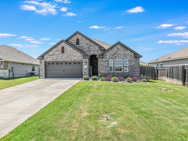 view of front of house featuring a front lawn, a garage, and central air condition unit