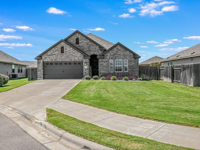 view of front of home with a garage, a front yard, and central AC unit