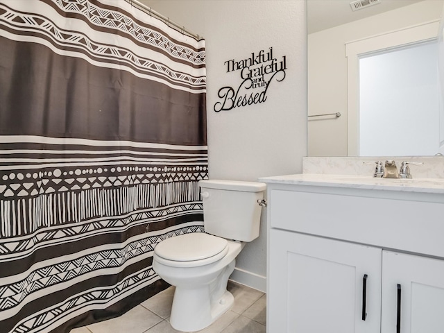 bathroom featuring tile patterned flooring, vanity, toilet, and walk in shower